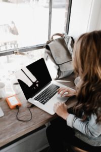 Woman typing on computer, symbolizing going serverless with AWS lambda